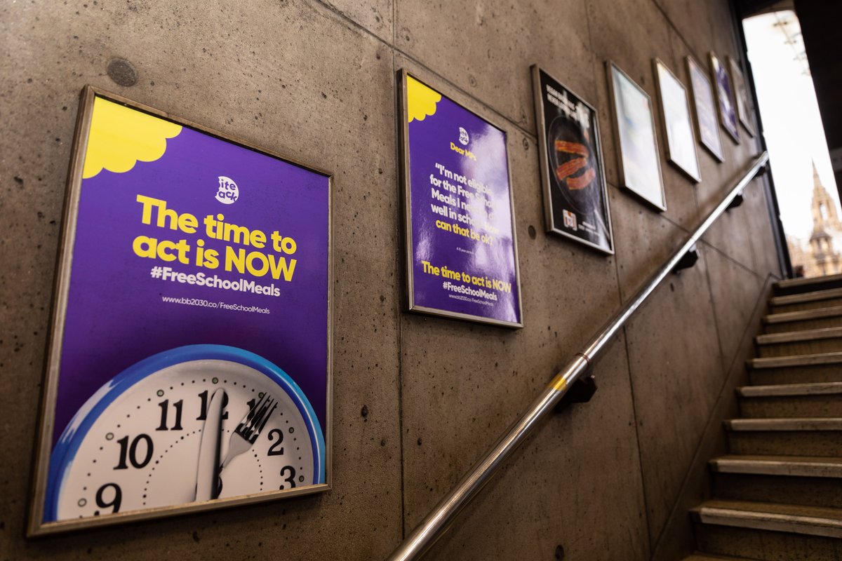 Two posters on the tube one showing a clock saying "The time to act is NOW #FreeSchoolMeals", the other saying "Dear MPs, I am not eligible for the free school meals I need to do well in school. How can that be ok? The time to act is NOW #FreeSchoolMeals"