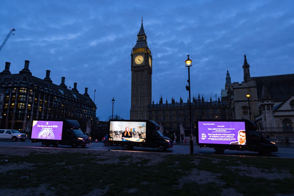 A group of digivans driving past Big Ben showing 'The Time To Act is Now' and an image from our free school meals film.