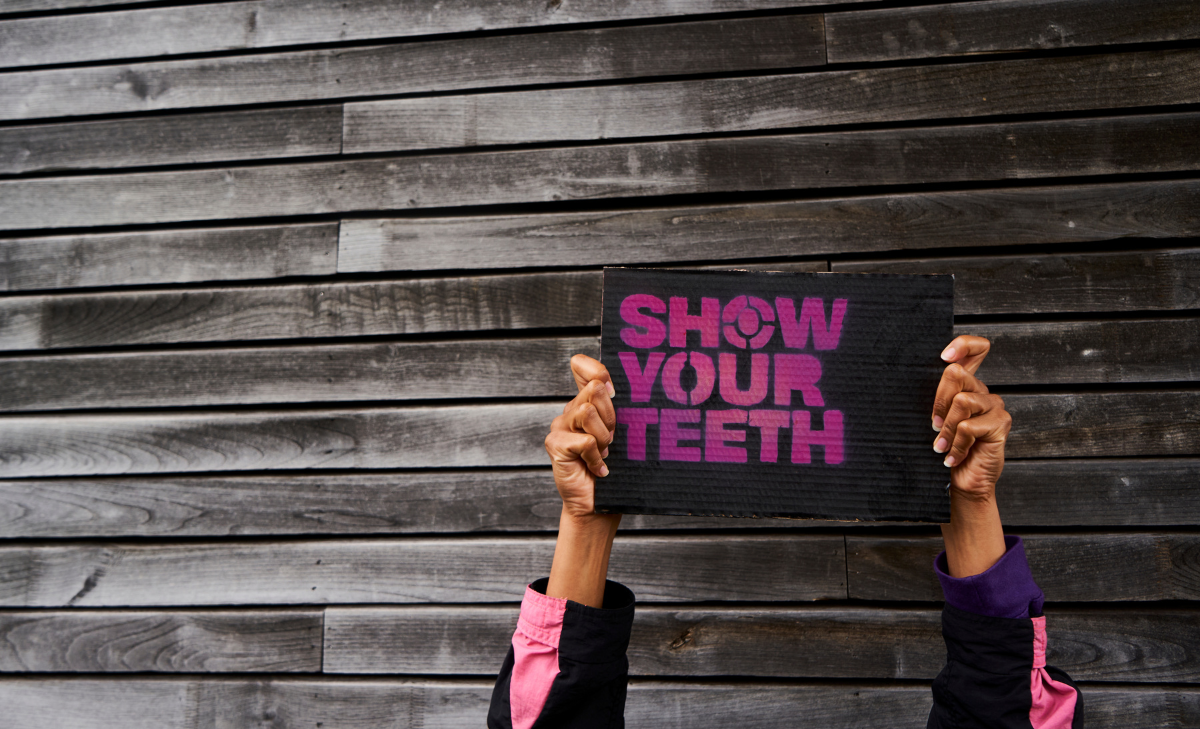Show Your Teeth protest sign