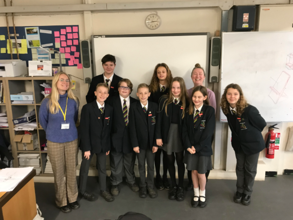 Kaya, a blonde woman from the Bite Back staff team, stands with a group of school students from our school food champions programme.