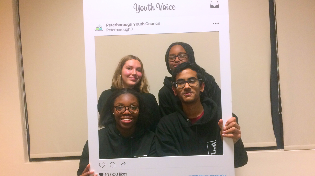 A group of 4 youth activists posing in a cardboard Instagram style frame that says 'Peterborough Youth Council' and 'Youth Power'.