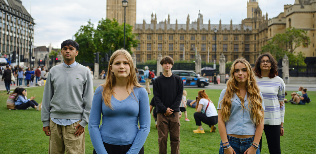 Five young people standing on Parliament square in front of Parliament looking ready to bite back at the food system.