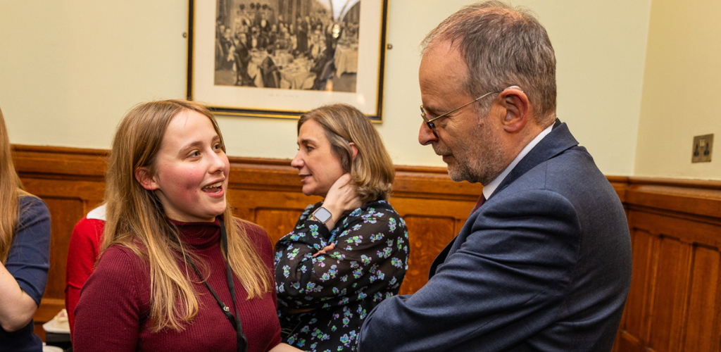 Bite Back activist Anna is talking to an MP at a Bite Back Parliamentary Reception event in March 2024